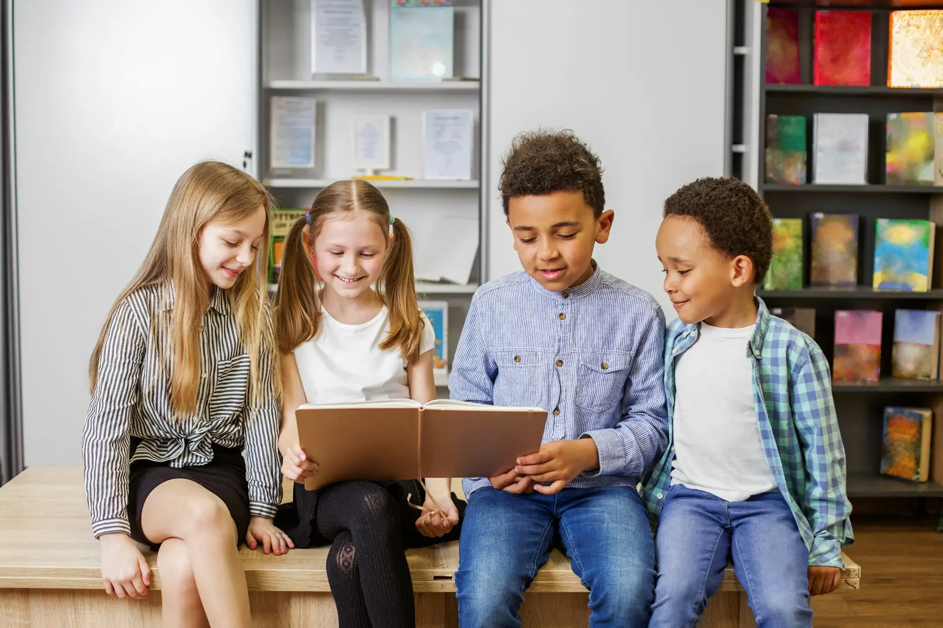 Group happy children reading book in classroom. Back to school. Study and education concept